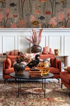 a living room filled with lots of furniture and flowers on the wall behind it,