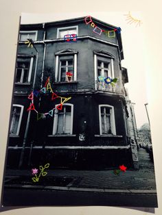 an old black building with colorful streamers hanging from it's windows