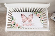 a white crib with a pink butterfly on it