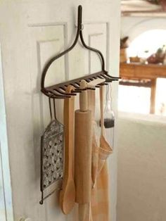 a rack with wooden utensils hanging from it's hooks on a door