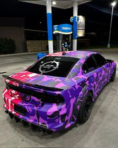 a purple camo car parked at a gas station