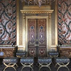 an ornately decorated room with two benches and a chandelier