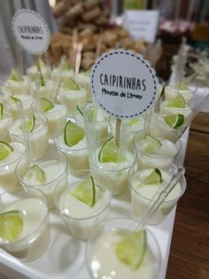 there are many cups with limes in them on the table and one has a sign that says caprinhas