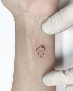 a person with a small tattoo on their left arm and the sky is raining behind them