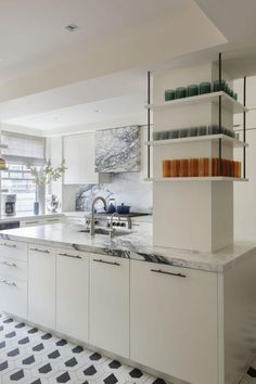 a kitchen with black and white checkered flooring, marble counter tops and open shelving