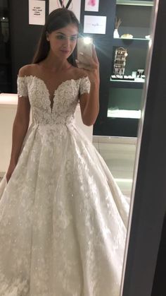 a woman is taking a selfie in her wedding dress while looking into the mirror