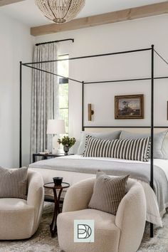 a bedroom with four poster bed, two chairs and a chandelier hanging from the ceiling