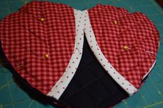 two red and white hearts sitting on top of a cutting board