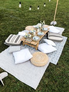 a picnic table set up with pillows and place settings