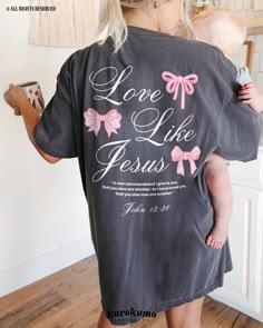 This Unisex garment-dyed t-shirt features "Love Like Jesus | 'A new commandment I give to you, that you love one another; as I have loved you, that you also love one another.' | John 13:34" with lovely pink hand-drawn bows on the back and a single bow on the front. Spread the gospel in a beautiful way with this coquette-style Christian shirt <3 » A B O U T « ‣ This item is made to order using direct-to-garment (DTG) printing technology. This digital process involves the printer inks being jetted Do All Things In Love Shirt, Jesus Loves You Tee Shirt, Jesus Love Shirts, Jesus Love Blouses, Jesus Shirts Christian Clothing, Bow Graphic, Christian Tee Shirts, Christian Accessories, Christian Graphic Tees