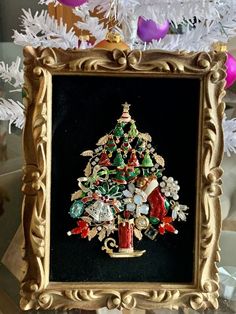 a small christmas tree in a gold frame