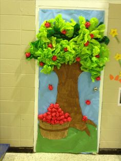 a door decorated to look like a tree with leaves and flowers on the bottom half