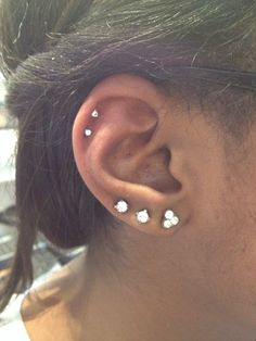 a woman with three piercings on her ear