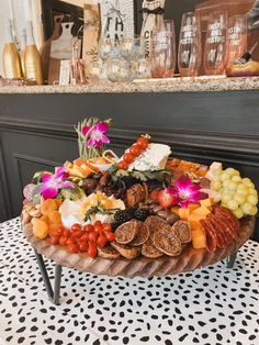 a platter filled with lots of different types of fruits and vegetables on top of a table