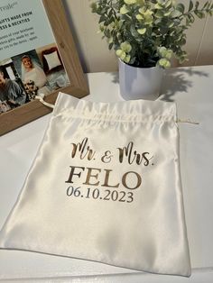 a couple's personalized wedding gift bag next to a photo frame and flowers