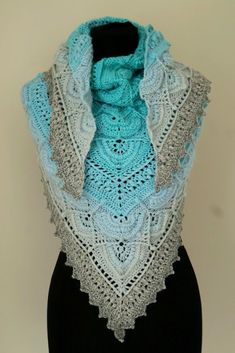 a white and blue shawl on top of a mannequin