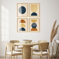 a dining room table with four chairs and three pictures on the wall above it, in front of a window