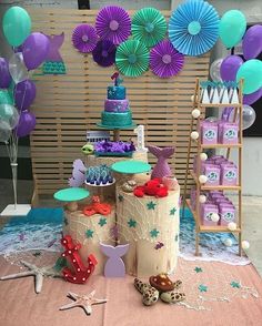 a table topped with lots of cakes and balloons