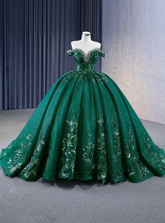 Daringly enchanting, this prom dress is designed to captivate and mesmerize. The rich emerald green hue, adorned with glittering accents, evokes the enchanting beauty of a lush, magical forest. The off-the-shoulder bodice is intricately embellished with sparkling details, highlighting your neckline and shoulders with a touch of elegance and sophistication. The voluminous skirt flows gracefully to the floor, creating a dramatic and regal silhouette. As you move, the shimmering fabric catches the light, creating a magical effect that will captivate everyone around you. Imagine making your grand entrance in this gown, the layers of the skirt swaying with each step, exuding grace and confidence. This dress is perfect for those who want to combine timeless elegance with a hint of modern glamour 15 Dresses Quinceanera Emerald Green, Quinceanera Emerald Green Dresses, Forest Green Ball Gown, Emerald Green 15 Dress, Dark Green Wedding Dress, Emerald Quinceanera Dress, Arabian Nights Prom Dress, Emerald Green Quince Dress, Emerald Green Wedding Dress