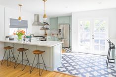 a kitchen with two stools next to an island