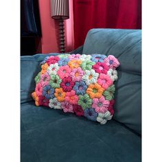 a crocheted pillow sitting on top of a blue couch