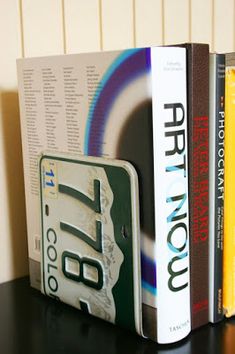 three books are stacked on top of each other in front of a bookend with the word art now