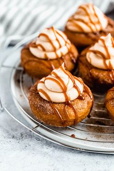 a metal plate topped with mini cinnamon buns covered in icing and drizzled