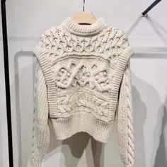 a white sweater hanging on a clothes rack