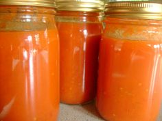 three jars filled with bright orange colored liquid