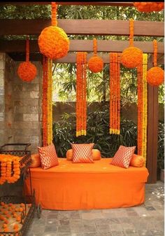 an orange couch with pillows and pom poms hanging from it's sides