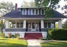 a gray and white house with red steps