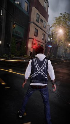 a man walking across a street in front of a red traffic light with his back turned to the camera