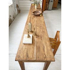 a long wooden table with two chairs and a plate on the table next to it