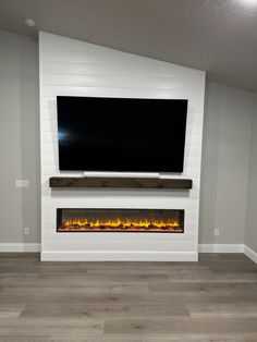 a flat screen tv mounted on the wall above a fireplace