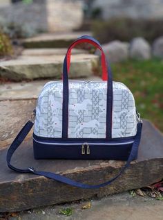 a white and blue bag sitting on top of a rock