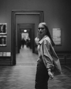 a woman walking down a hallway talking on a cell phone