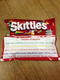 two skittles candy bars sitting on top of a wooden table