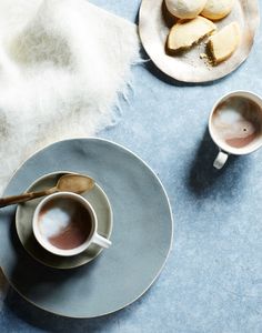 two cups of coffee and some cookies on a plate