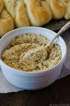 a white bowl filled with food next to rolls