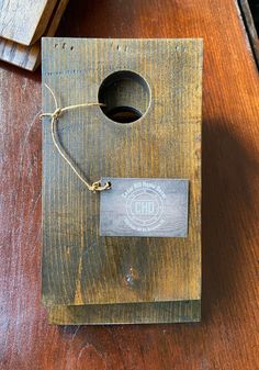 a wooden birdhouse with a tag attached to it