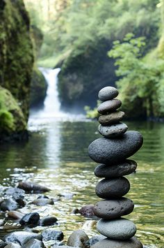 rocks stacked on top of each other in front of a waterfall