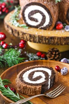 a piece of cake on a wooden plate with a fork and christmas decorations around it