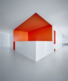 an orange and white building in the middle of a room with no one around it