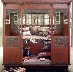 an ornately decorated bed in the middle of a room with lots of pillows on it