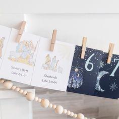 three calendars hanging from clothes pegs on a string with wooden bead garland