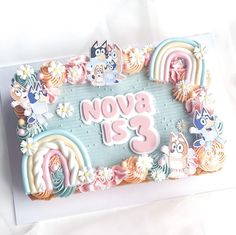 there is a birthday cake decorated with pastel colors and flowers on the bottom layer