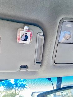 the inside of a car with pictures on the dash board and other things in the back seat