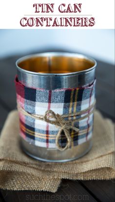 an empty tin can sitting on top of a cloth covered tablecloth with a string tied to it