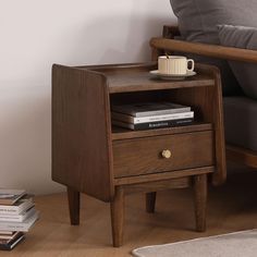 a wooden table with two drawers and a coffee cup on the top, next to a couch