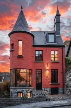 a red brick house with a steeple on the top and windows in front at sunset